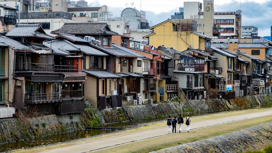 a group of people walking on a street between rows of houses
