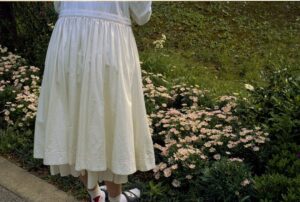 woman in white dress standing on green grass field