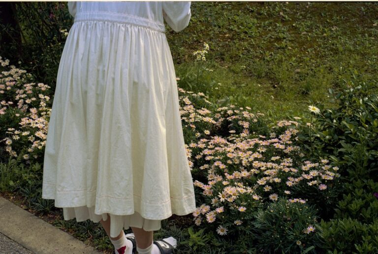 woman in white dress standing on green grass field