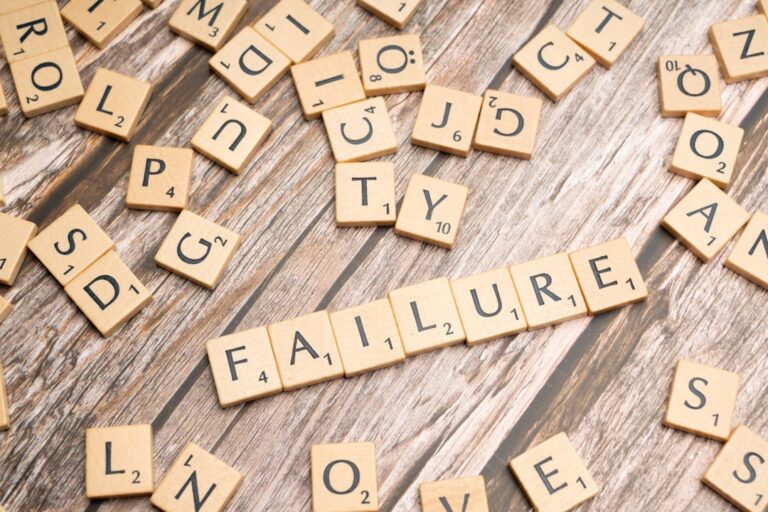 scrabble tiles spelling failure and love on a wooden surface