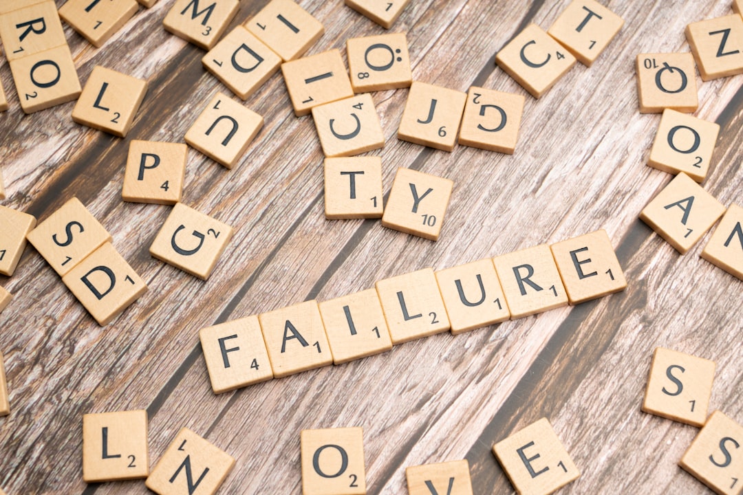 scrabble tiles spelling failure and love on a wooden surface