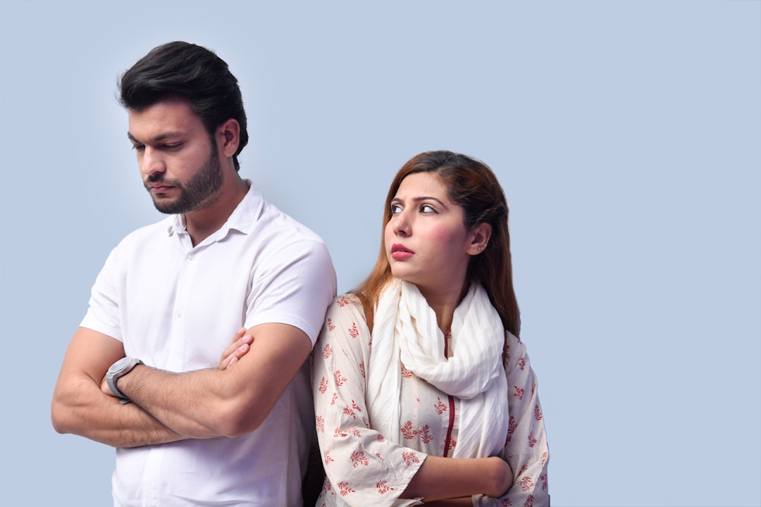 a man and a woman standing next to each other and looking at the camera