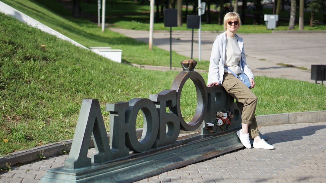 A woman sitting on the letters of a sign